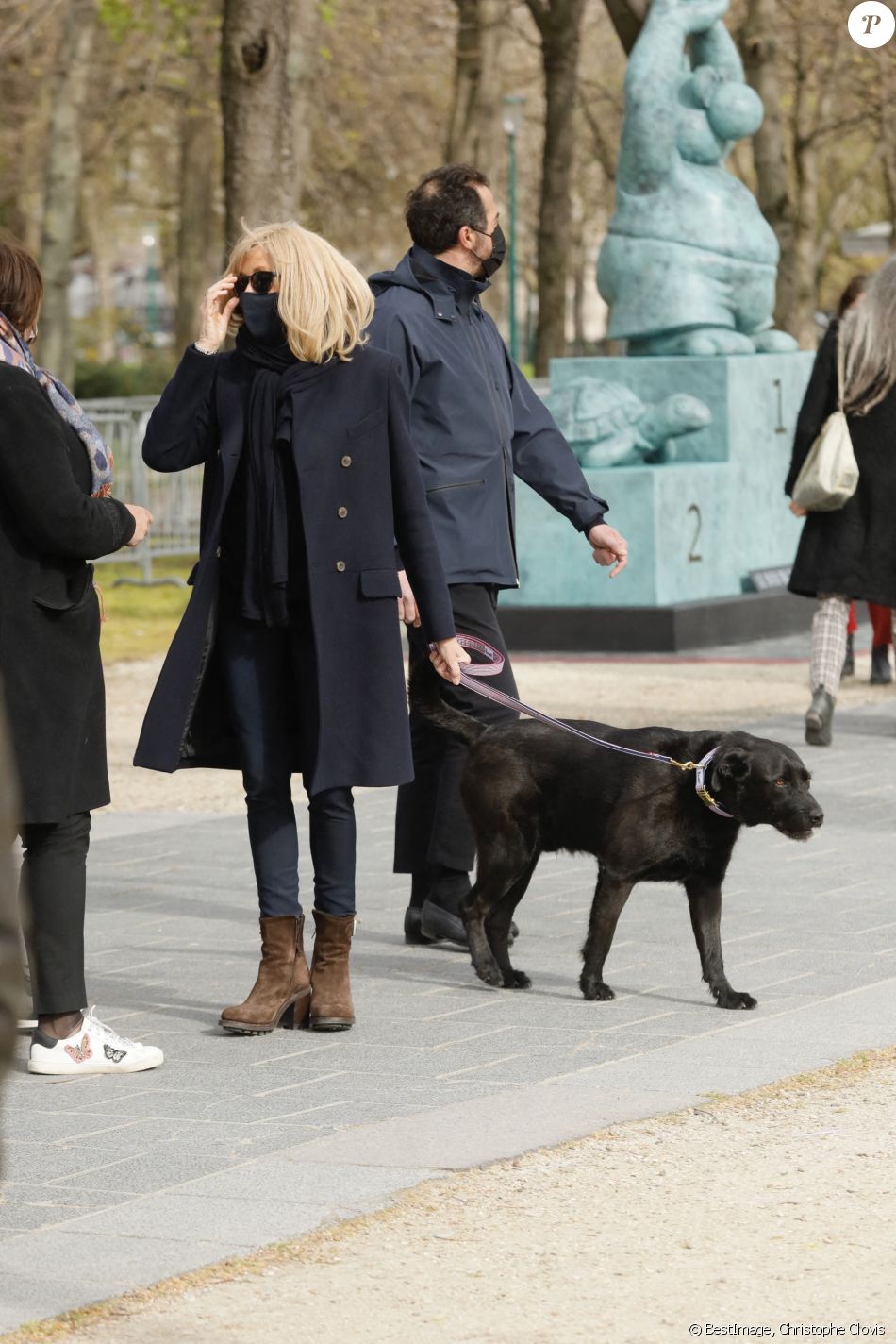 La première Dame Brigitte Macron balade son chien, Némo, sur l'avenue des Champs-Élysées, à Paris, France, le 26 mars 2021. La première Dame s'est rendue à l'exposition des 20 statues du "Chat" de Philippe Geluck. © Christophe Clovis/Bestimage