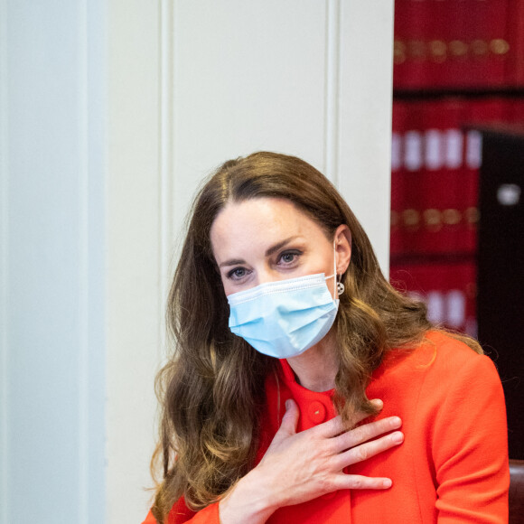 Catherine (Kate) Middleton, duchesse de Cambridge, dans son long manteau rouge et un sac à main en cuir DeMellier, visite les archives du musée National Portrait Gallery (NPG) à Londres, Royaume Uni, le 7 mai 2021.