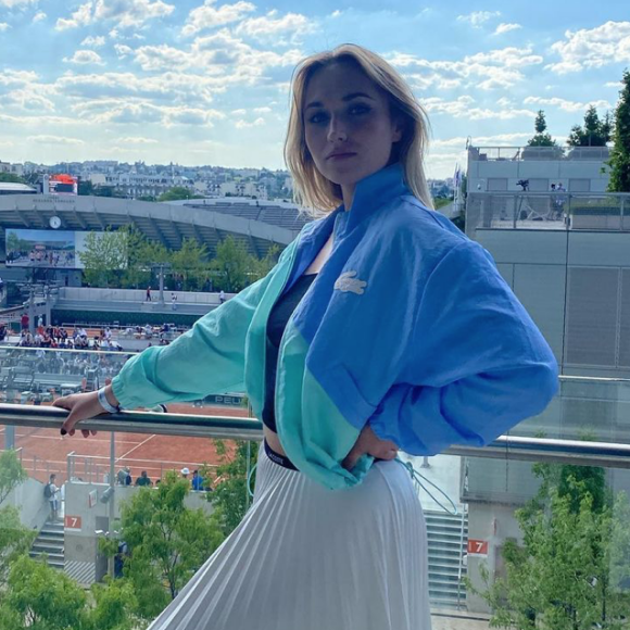 Chloé Jouannet, ultrastylée en veste coupe-vent et jupe plissée Lacoste, à Roland-Garros.