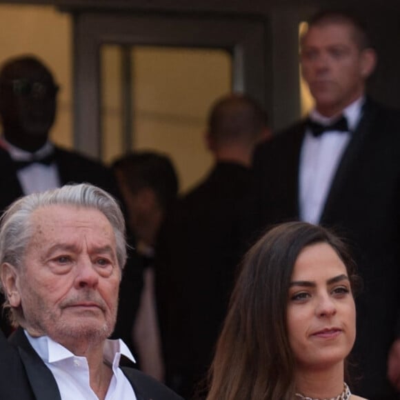 Alain Delon (Palme d'Or d'Honneur du 72ème festival de Cannes avec un badge Paris Match d'une ancienne couverture du magazine titrant "Alain Delon, mes deux amours, Rosalie et Anouchka) et sa fille Anouchka (Robe Elie Saab) - Montée des marches du film "A Hidden Life" lors du 72ème Festival International du Film de Cannes. Le 19 mai 2019