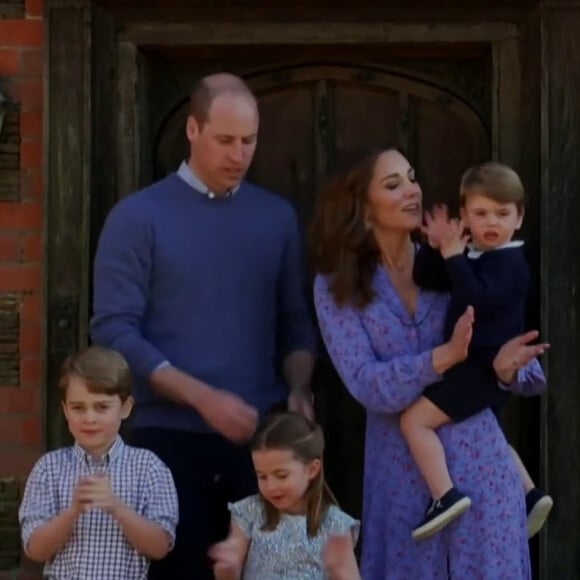 Captures d'écran d'une vidéo inédite de la famille royale dévoilée lors d'un sketch hilarant avec le prince William et Stephen Fry. L'humour anglais dans toute sa splendeur. Ce jeudi 23 avril, pour un sketch qui visait à récolter des fonds pour le personnel soignant britannique, le prince William a accepté de jouer la comédie avec le renommé Stephen Fry. A la fin de la vidéo, on a pu voir le prince se réunir avec Kate Middleton et leurs trois enfants, George, Charlotte et Louis devant chez eux pour applaudir le personnel soignant.Le prince William, Kate Middleton et leurs trois enfants, George, Charlotte et Louis applaudissent le personnel soignant devant leur demeure d'Anmer Hall, pendant le confinement