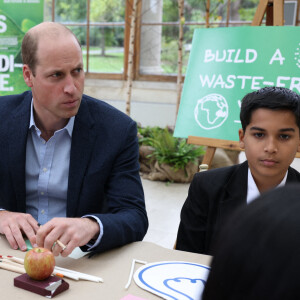 Le prince William, duc de Cambridge, entouré d'élèves de l'école Heathlands, lors d'une visite aux jardins botaniques royaux de Kew pour l'événement "Generation Earthshot" à Londres, le 13 octobre 2021.