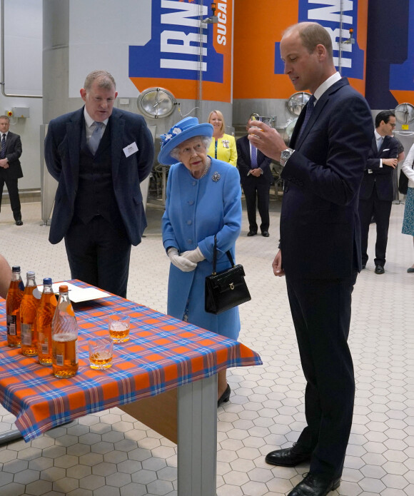 La reine Elisabeth II d'Angleterre et Le prince William, duc de Cambridge (connu sous le nom de comte de Strathearn en Écosse) visitent l'usine AG Barr, où la boisson Irn-Bru est fabriquée, à Cumbernauld, le 28 juin 2021.