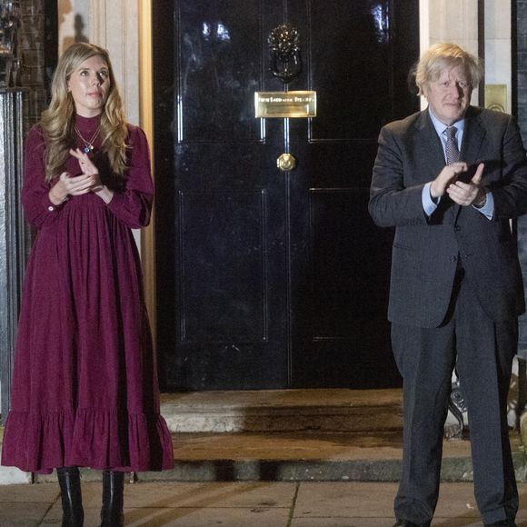 Le premier ministre Boris Johnson et sa compagne Carrie Symonds applaudissent devant le 10 Downing Street pour rendre hommage au capitaine Tom Moore, vétéran et héros du confinement décédé à l'âge de 100 ans. Londres, le 3 février 2021