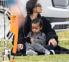 Kim Kardashian regarde le match de football de son fils Saint, assise sur la pelouse avec sa fille Chicago à Los Angeles le 3 avril 2022. 