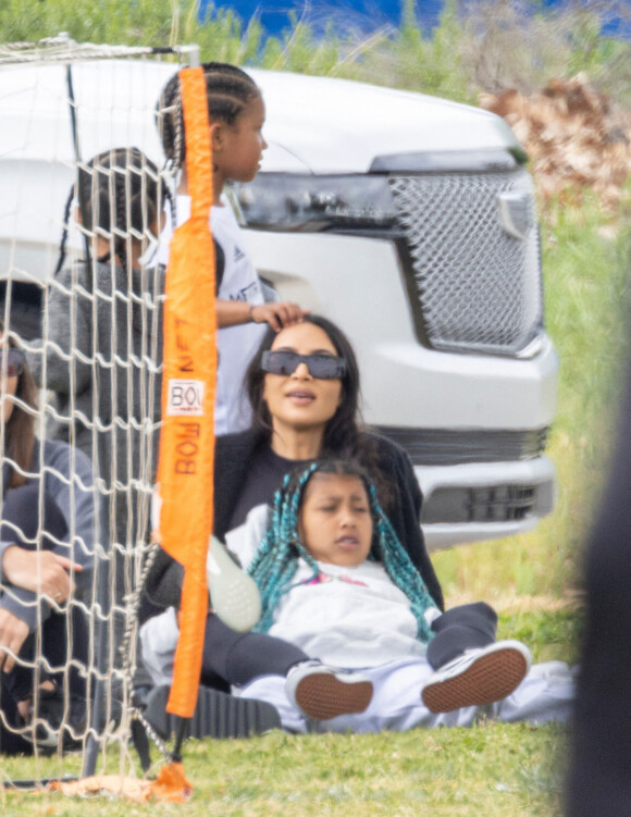 Kim Kardashian regarde le match de football de son fils Saint, assise sur la pelouse avec sa fille North à Los Angeles le 3 avril 2022. 