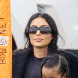 Kim Kardashian regarde le match de football de son fils Saint, assise sur la pelouse avec sa fille Chicago à Los Angeles le 3 avril 2022. 