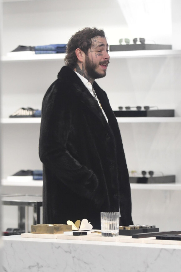 Post Malone boit une coupe de champagne en virée shopping avec des amis chez Saint Laurent dans le quartier de Beverly Hills à Los Angeles, le 4 décembre 2019