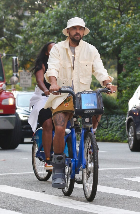 Jesse Williams fait du vélo en portant une attelle de pied à New York le 12 septembre 2021. L'acteur était accompagné d'une mystérieuse inconnue. 