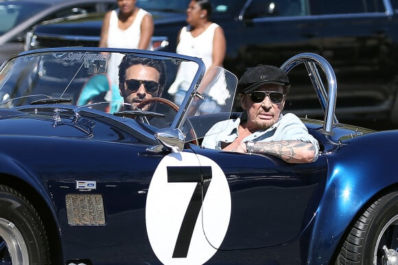 Johnny Hallyday accompagné de Maxim Nucci (Yodelice), arrive au restaurant "Soho House" à Malibu, au volant de son cabriolet AC Cobra marqué de son chiffre porte-bonheur, le numéro 7. Laeticia Hallyday, toujours en béquilles, les rejoint dans une autre voiture. Malibu, le 09 mars 2017.