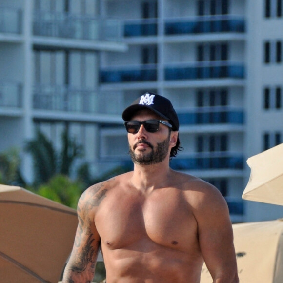 David Guetta et sa compagne Jessica Ledon, avec son ami le DJ Cédric Gervais et sa fiancée Adriana Gutierrez, se prélassent sur la plage du palace Setai à Miami, le 20 mars 2022. 