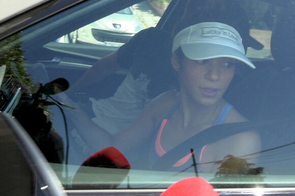 Shakira salue les journalistes en quittant son domicile au volant de sa voiture à Barcelone, le 24 août 2022.