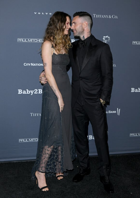 Behati Prinsloo et son mari Adam Levine au photocall du 10ème anniversaire du gala "Baby2Baby" à Los Angeles, le 14 novembre 2021.