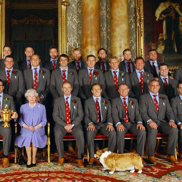 La reine Elisabeth II d'Angleterre en 2003 avec l'équipe d'Angleterre et ses corgis