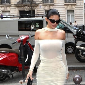 Kylie Jenner arrive pour des essayages chez Balenciaga lors de la Fashion Week de Paris, France, le 1er octobre 2022. Kylie porte une robe moulante blanche et des talons bleu. 