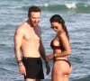 David Guetta et sa compagne Jessica Ledon, qui arbore un diamant à l'annulaire gauche, passent du bon temps sur la plage en compagnie de leur petit chien. Miami, le 23 novembre 2018. 