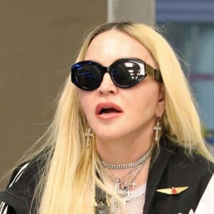 Exclusif - Madonna et son fils David Banda, 16 ans, arrivent à l'aéroport JFK à New York, le 11 août 2022. Au moment de passer le contrôle avant d'embarquer, la chanteuse de 63 ans laisse apparaître son tee-shirt en résille transparent.