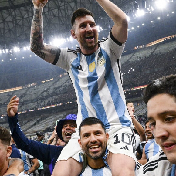 Lionel Messi soulevant le trophee de la Coupe du Monde et porte en triomphe par ses coequipiers - Remise du trophée de la Coupe du Monde 2022 au Qatar (FIFA World Cup Qatar 2022) à l'équipe d'argentine après sa victoire contre la France en finale (3-3 - tab 2-4). Doha, le 18 décembre 2022.