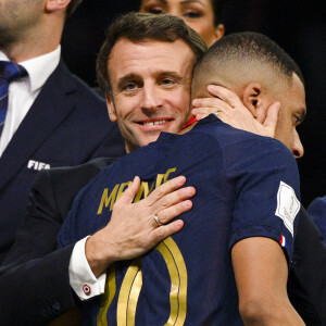 Déception de MBAPPE Kylian (FRA) accolade avec Emmanuel Macron - president de la Republique Francaise - Remise du trophée de la Coupe du Monde 2022 au Qatar (FIFA World Cup Qatar 2022) à l'équipe d'argentine après sa victoire contre la France en finale (3-3 - tab 2-4). Doha.