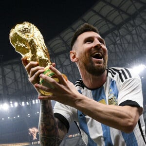 Lionel Messi soulevant le trophee de la Coupe du Monde et porte en triomphe par ses coequipiers - Remise du trophée de la Coupe du Monde au Qatar à l'équipe d'argentine après sa victoire contre la France en finale. Doha.