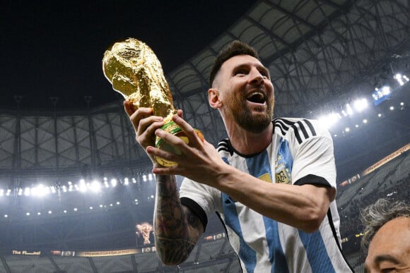 Lionel Messi soulevant le trophee de la Coupe du Monde et porte en triomphe par ses coequipiers - Remise du trophée de la Coupe du Monde au Qatar à l'équipe d'argentine après sa victoire contre la France en finale. Doha.