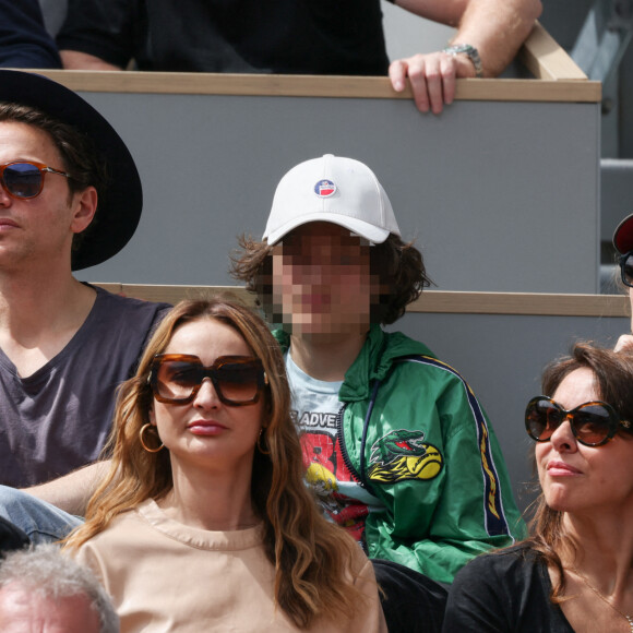 Mélanie Thierry et son compagnon le chanteur Raphael et leur fils Roman en tribunes lors des Internationaux de France de tennis de Roland Garros à Paris, France, le 26 mai 2022. 
