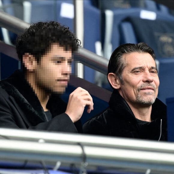 Kool Shen a également partagé ce moment avec son fils Giani. 
Kool Shen (Bruno Lopes) et son fils Giani dans les tribunes lors du match de Ligue 1 "PSG - Lille (4-3)" au Parc des Princes, le 19 février 2023. 