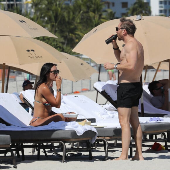 David Guetta et sa compagne Jessica Ledon profitent d'une journée sur une plage de Miami, malgré les rumeurs de séparation, le 24 février 2023. 