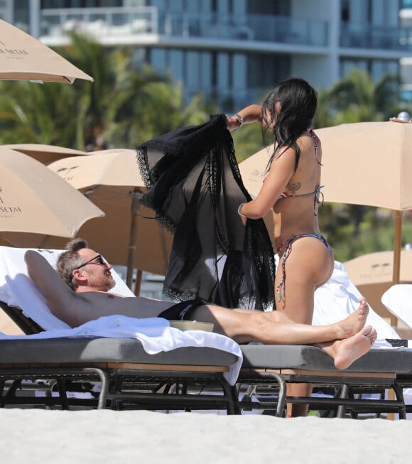David Guetta et sa compagne Jessica Ledon profitent d'une journée sur une plage de Miami, malgré les rumeurs de séparation, le 24 février 2023. 
