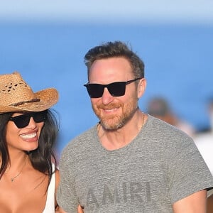 Malgré les rumeurs de séparation, David Guetta et sa compagne Jessica Ledon amoureux plus que jamais profitent d'une journée sur une plage de Miami avec leur chien le 19 février 2023. 