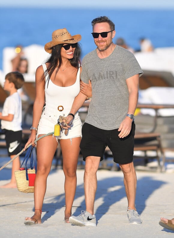 Malgré les rumeurs de séparation, David Guetta et sa compagne Jessica Ledon amoureux plus que jamais profitent d'une journée sur une plage de Miami avec leur chien le 19 février 2023. 