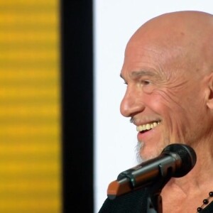 Florent Pagny tout sourire sur le plateau de "20h30 le dimanche", sur France 2, présenté par Laurent Delahousse, le 2 avril 2023.