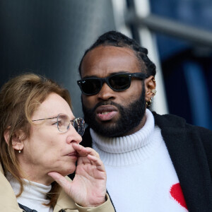 Emmanuelle Bercot et un ami - People au match de football "PSG vs Lorient" au Parc des Princes à Paris. Le 30 avril 2023 © Cyril Moreau / Bestimage
