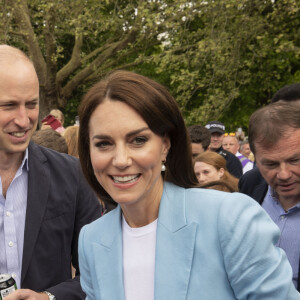 Le prince William, prince de Galles, et Catherine (Kate) Middleton, princesse de Galles, à la rencontre des membres du public participant au pique-nique du couronnement du roi sur la longue marche du parc du château de Windsor, Royaume Uni, le 7 mai 2023.