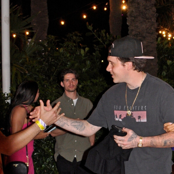 Brooklyn Beckham pose avec un jeune fan en quittant la soirée "Supper Club Carbone Beach" à Miami avec sa femme Nicola Peltz le 7 mai 2023.