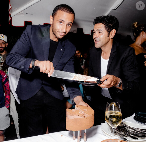 C'est la superstar de la cuisine Yazid Ichemrahen qui a dévoilé les coulisses de l'anniversaire de Jamel Debbouze.
Exclusif - Le pâtissier Yazid Ichemrahen et Jamel Debbouze - Les célébrités fêtent le 48ème anniversaire de J.Debbouze dans le restaurant "Dar Mima", créé par Laurent de Gourcuff et J.Debbouze, en hommage à la mère de ce dernier, Fatima. Sur le toit de l'Institut du monde arabe à Paris, l'acteur a partagé son gâteau d'anniversaire avec sa femme, M.Theuriau, et ses amis, dont l'équipe du "Jamel Comedy Club". Oeuvre du pâtissier Yazid Ichemrahen, champion du monde de pâtisserie, le gâteau était composé d'un biscuit Brownie, de croustillant amande, de fleur de sel, de mousse au chocolat pur du Venezuela (62%), de crème et de passion du Cameroun. Le film "A la belle étoile", sorti en salles et co-produit par J.Debbouze, s'inspire de la vie de Yazid Ichemrahen.  No web pour la Belgique et la Suisse