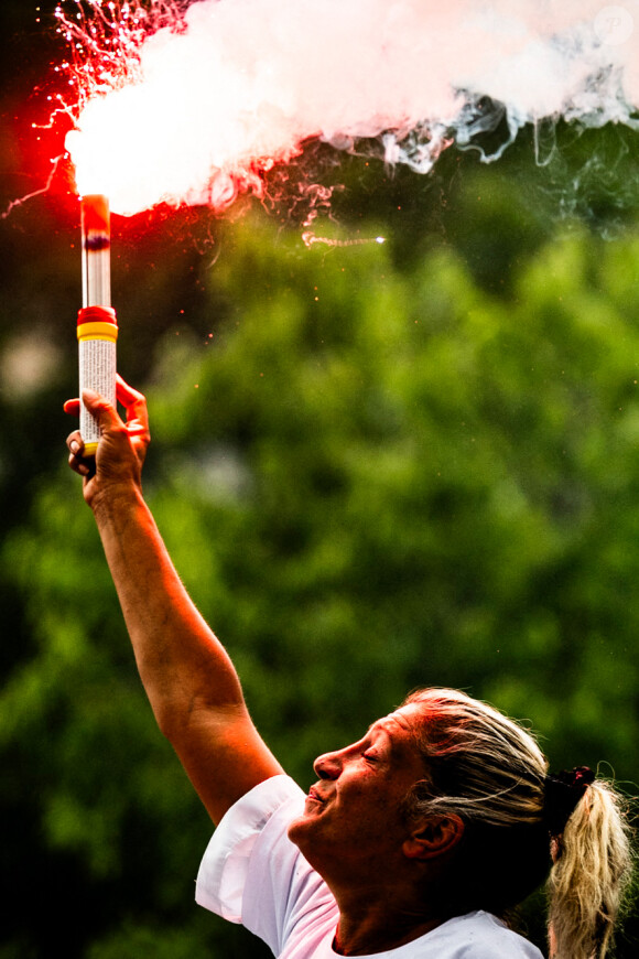 Mounia, la mère de Nahel (Naël), brandissant un fumigène avec le regard en l'air lors de la Marche blanche en hommage à son fils, tué par un policier. Nanterre, le 29 juin 2023 © JB Autissier / Panoramic / Bestimage 