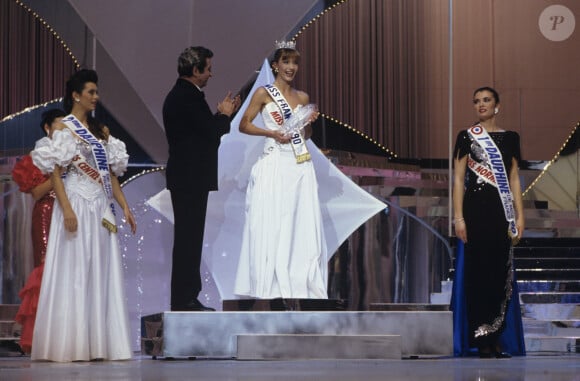 En France, à Paris, Lors de l'Election de Miss France 1990, Gilbert Becaud applaudissant Gaëlle Voiry Miss France 90 sur le podium, entourée de ses dauphines Karine Richefeu MIss Centre Ouest 2ème dauphine, Céline Marteau Miss Normandie 1ère dauphine en décembre 1989