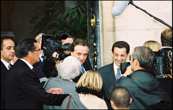 En effet, Michel Sardou s'est permis une "réflexion qui ne lui a pas plu : j'étais à l'Élysée en costume-cravate, lui était en short."
Michel Sardou et Nicolas Sarkozy en 1999.
