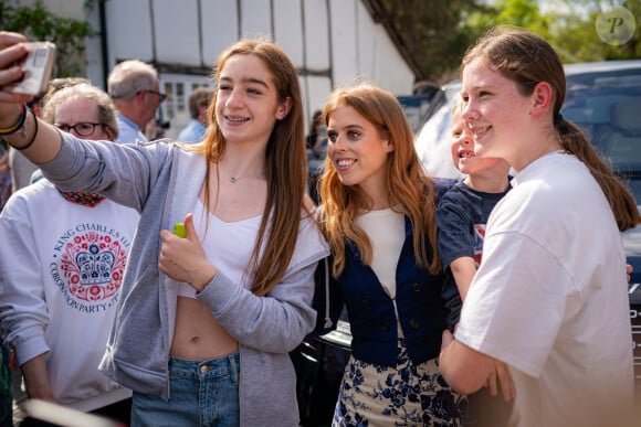 Ben Birchall_72068031 - La princesse Eugenie d'York, enceinte, et la princesse Beatrice d'York assistent au "Big Lunch" du couronnement à Chalfont St Giles (Buckinghamshire)  La princesse Eugenie d'York, enceinte, et la princesse Beatrice d'York (veste bleue) assistent au "Big Lunch" du couronnement à Chalfont St Giles (Buckinghamshire), le 7 mai 2023. Des centaines de sujets britanniques à travers le pays fêtent le sacre du roi d'Angleterre et de la reine consort, célébré la veille à l'abbaye de Westminster à Londres.  Princess Beatrice (centre) poses for selfies as she and her sister, Princess Eugenie, attend the Coronation Big Lunch in Chalfont St Giles, Buckinghamshire. Thousands of people across the country are celebrating the Coronation Big Lunch on Sunday to mark the crowning of King Charles III and Queen Camilla. Picture date: Sunday May 7, 2023.