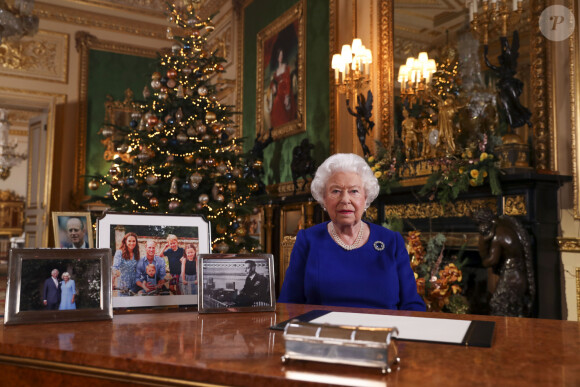 La reine Elizabeth II d'Angleterre enregistre sa diffusion annuelle de Noël au château de Windsor, dans le Berkshire le 24 décembre 2019. Comme on peut le constater sur son bureau, il n'y a aucune photo de son petit-fils le prince Harry en famille ni même de photo de son fils le prince Andrew duc d'York. 