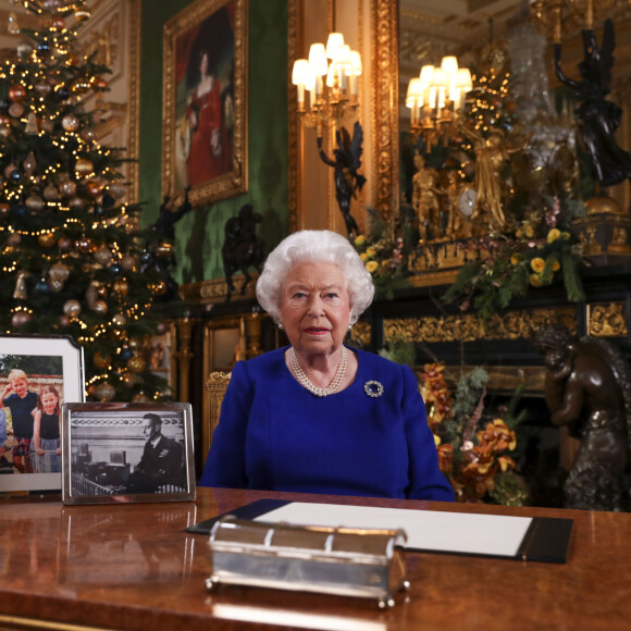 La reine Elizabeth II d'Angleterre enregistre sa diffusion annuelle de Noël au château de Windsor, dans le Berkshire le 24 décembre 2019. Comme on peut le constater sur son bureau, il n'y a aucune photo de son petit-fils le prince Harry en famille ni même de photo de son fils le prince Andrew duc d'York. 