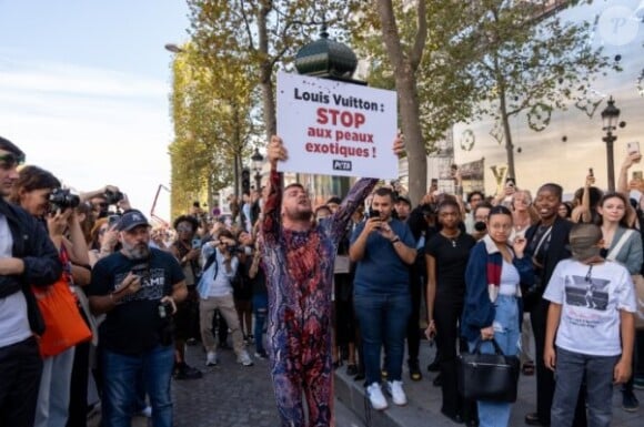En tenue de "serpent dépecé" sur les Champs-Elysées.
Jeremstar manifeste devant le défilé Louis Vuitton.