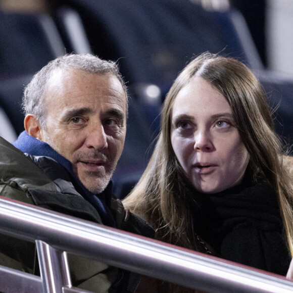 Elie Semoun et sa compagne dans les tribunes lors du match de Ligue 1 Uber Eats "PSG - Monaco (5-2)" au Parc Des Princes, le 24 novembre 2023. © Cyril Moreau/Bestimage