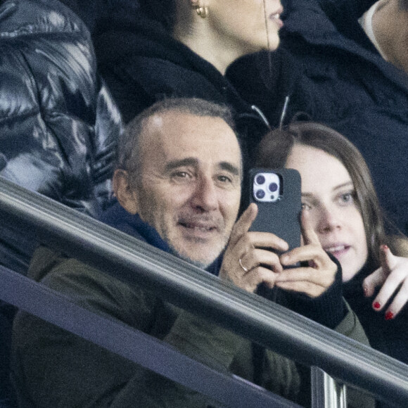 Elie Semoun et sa compagne dans les tribunes lors du match de Ligue 1 Uber Eats "PSG - Monaco (5-2)" au Parc Des Princes, le 24 novembre 2023. © Cyril Moreau/Bestimage