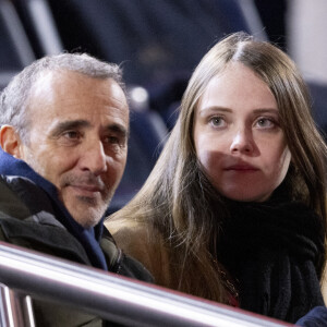 Elie Semoun et sa compagne dans les tribunes lors du match de Ligue 1 Uber Eats "PSG - Monaco (5-2)" au Parc Des Princes, le 24 novembre 2023. © Cyril Moreau/Bestimage