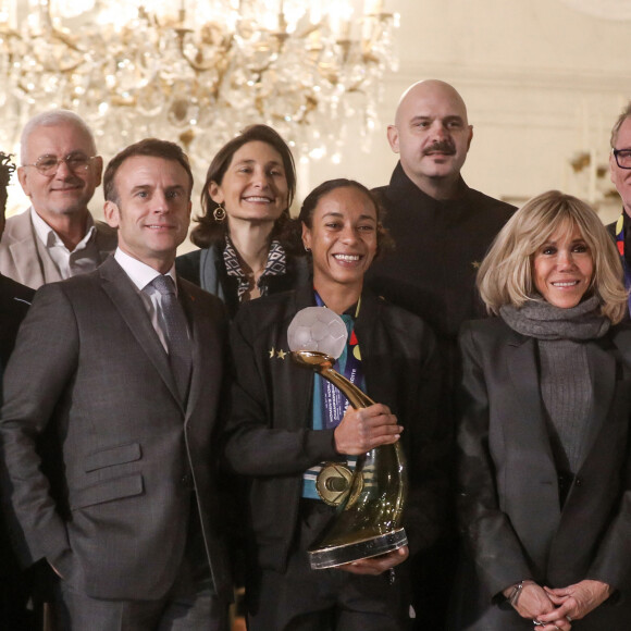 Le président français, Emmanuel Macron et la première dame, Brigitte Macron recoivent la capitaine de l'équipe de France de handball, Estelle Nze Minko et l'équipe de France féminine de handball championne du monde 2023 au palais de l'Elysée, le 18 décembre 2023 © Stéphane Lemouton / Bestimage