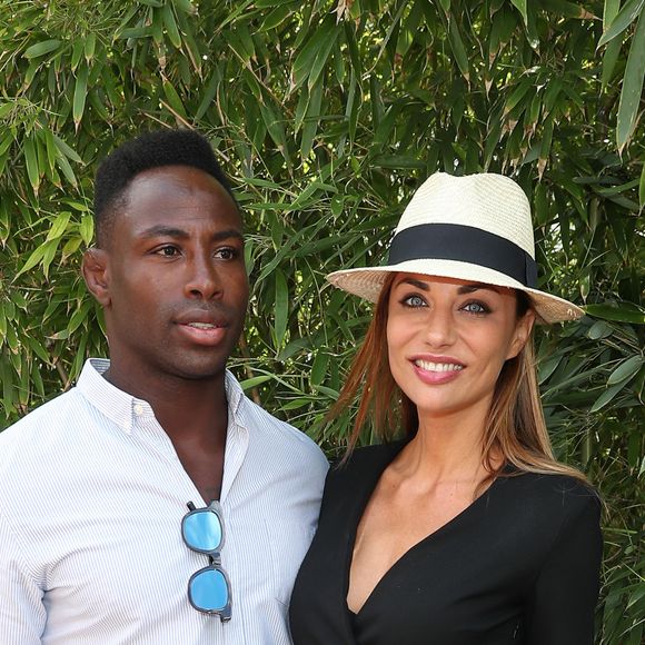 "Je me rappelle que la première fois que je l'ai vu, il était dans un restaurant. Et la table du restaurant elle était à je sais pas, 10 ou 15 mètres."
Ariane Brodier et son compagnon Fulgence Ouedraogo au village lors des internationaux de tennis de Roland Garros à Paris le 5 juin 2017. © Cyril Moreau / Dominique Jacovides / Bestimage