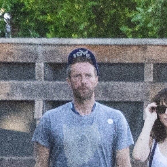 Exclusif - Chris Martin et sa compagne Dakota Johnson se promènent, enlacés, sur la plage de Malibu avec leur chien, le 18 octobre 2022.