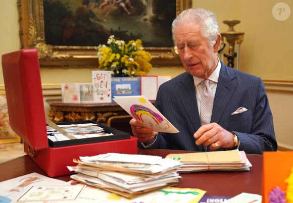 "Les problèmes de santé pourraient être une priorité pour Charles et Camilla" avait-elle fait savoir, indiquant qu'ils pourraient réduire les apparitions et se reposer sur le reste du clan
Le roi Charles III d'Angleterre, lit les messages reçus à Buckingham Palace à Londres, après le diagnostic sur son cancer, le 23 février 2024. 